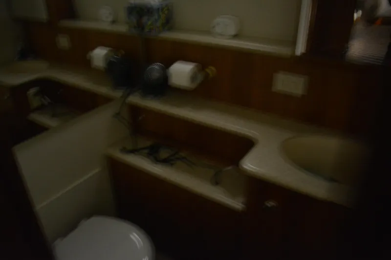Slide: The Image of 2001 Silverton 453 Motor Yacht bathroom with sink, toilet, and wooden cabinetry. - 44