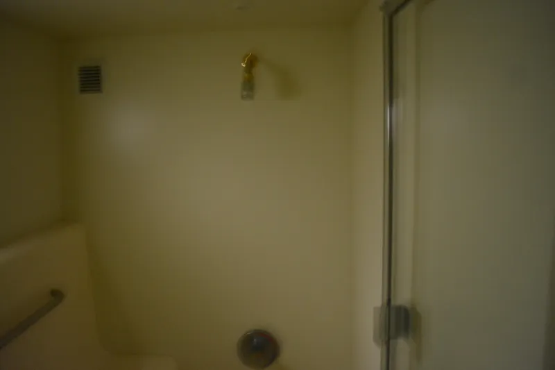 Slide: The Image of Shower area inside 2001 Silverton 453 Motor Yacht, featuring beige walls and a glass door. - 46