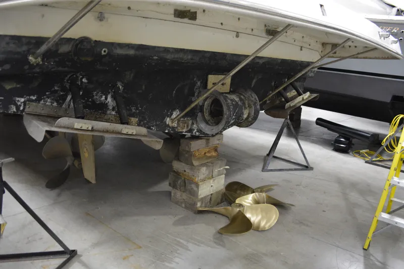 Slide: The Image of 2001 Silverton 453 Motor Yacht under maintenance, showing propellers and hull supported by blocks. - 9