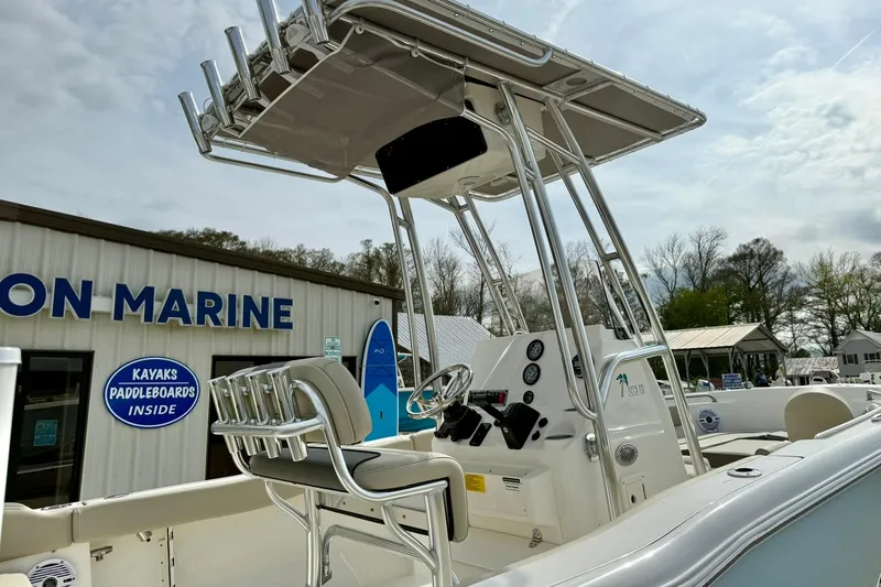 Slide: The Image of 2025 Key West 203 FS boat with T-top and seating, displayed at a marine dealership. - 11