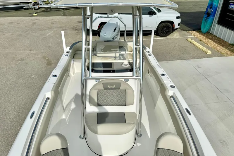 Slide: The Image of 2025 Key West 203 FS boat with seating and console, parked near a white vehicle. - 17