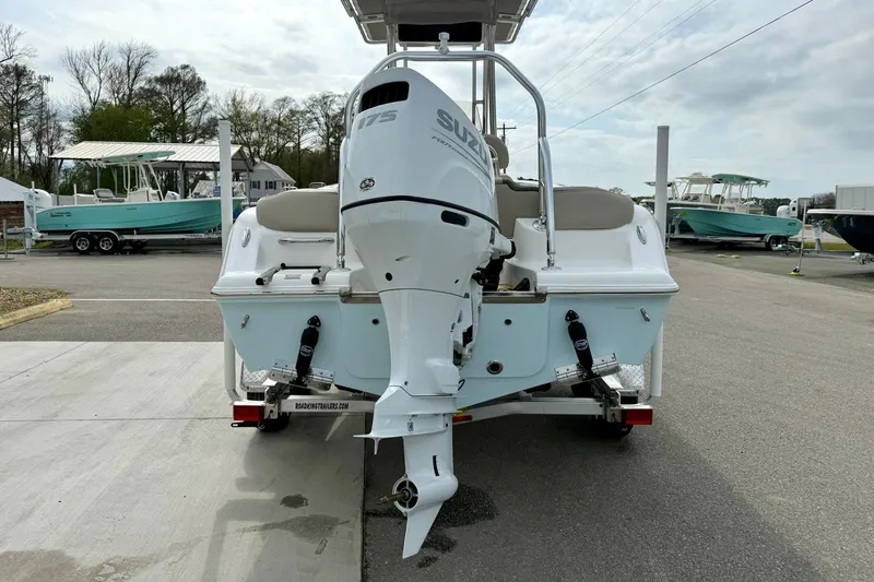 Slide: The Image of 2025 Key West 203 FS boat with Suzuki outboard motor, parked in a marina. - 2