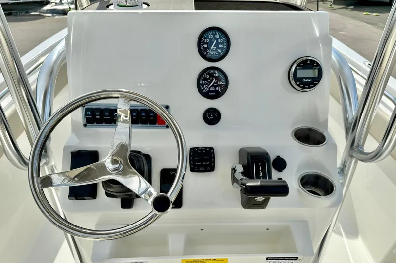 Slide: The Image of 2025 Key West 203 FS boat dashboard with steering wheel and control gauges. - 3