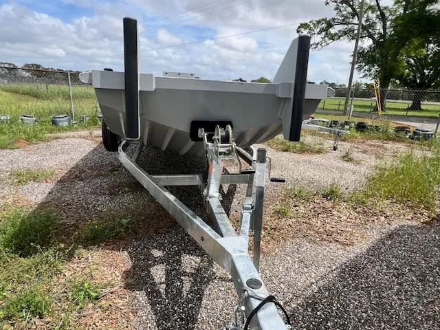 Slide: The Image of SeaArk 2672 Workhorse 2025 boat on trailer, parked on gravel, with grassy background. - 3
