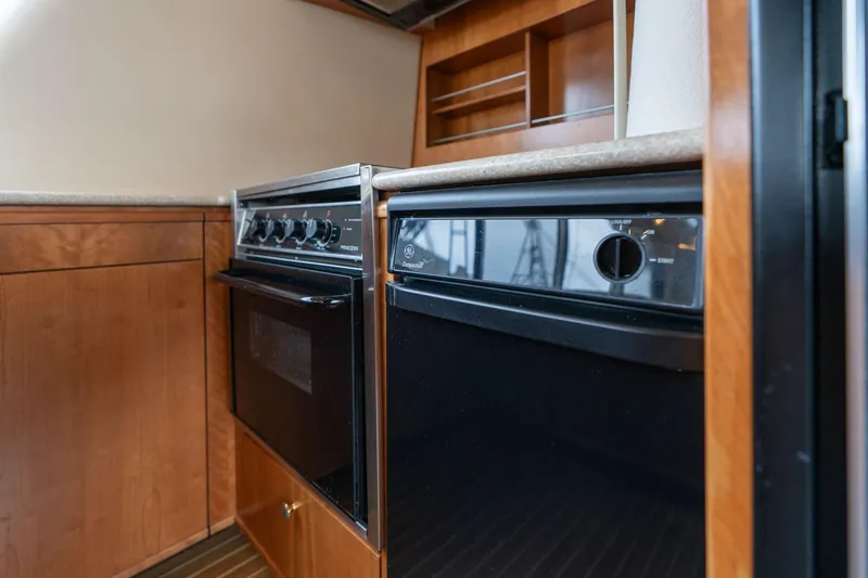 Slide: The Image of 2003 Meridian 490 Pilothouse kitchen with wood cabinetry and modern appliances. - 10