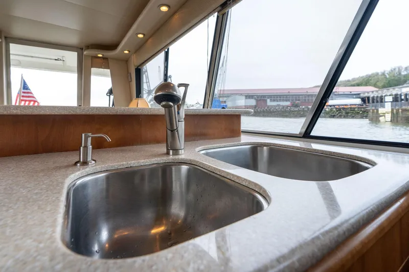 Slide: The Image of Double sink in 2003 Meridian 490 Pilothouse yacht kitchen with waterfront view. - 12