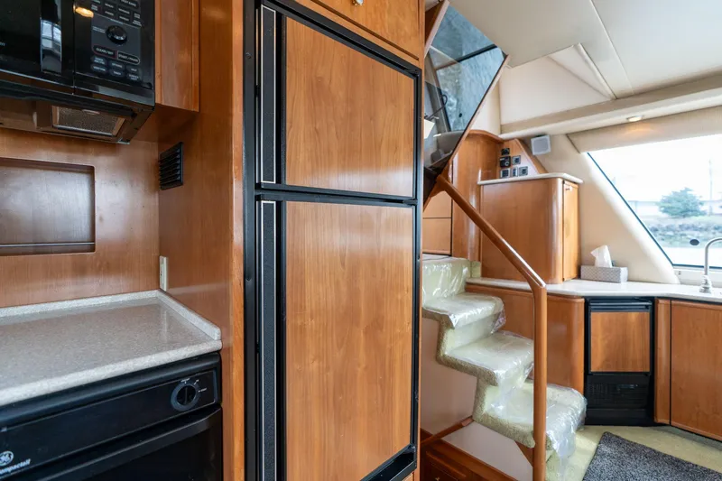 Slide: The Image of Interior of 2003 Meridian 490 Pilothouse with wooden cabinetry and staircase. - 15