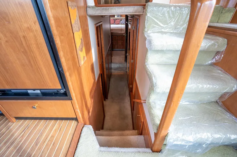Slide: The Image of Interior view of 2003 Meridian 490 Pilothouse yacht with carpeted stairs and wooden paneling. - 16