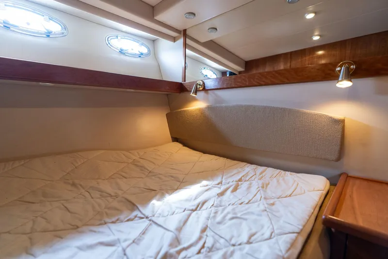 Slide: The Image of Cozy cabin interior of 2003 Meridian 490 Pilothouse yacht with bed and portholes. - 19