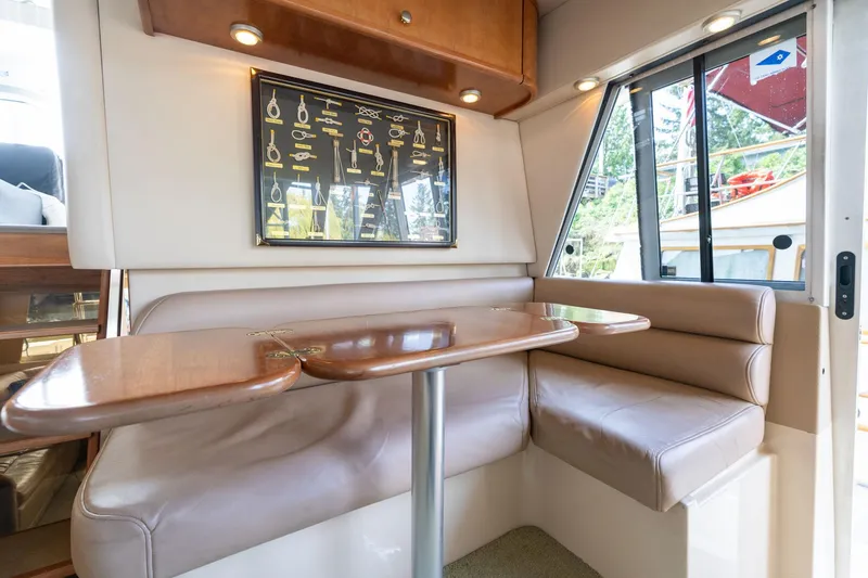 Slide: The Image of 2003 Meridian 490 Pilothouse interior with cozy dining area and nautical decor. - 37