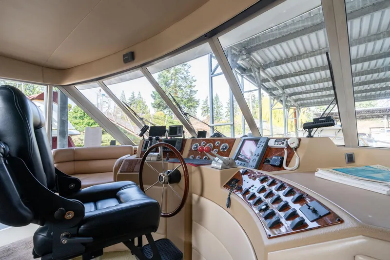 Slide: The Image of 2003 Meridian 490 Pilothouse interior with steering wheel and control panel. - 43