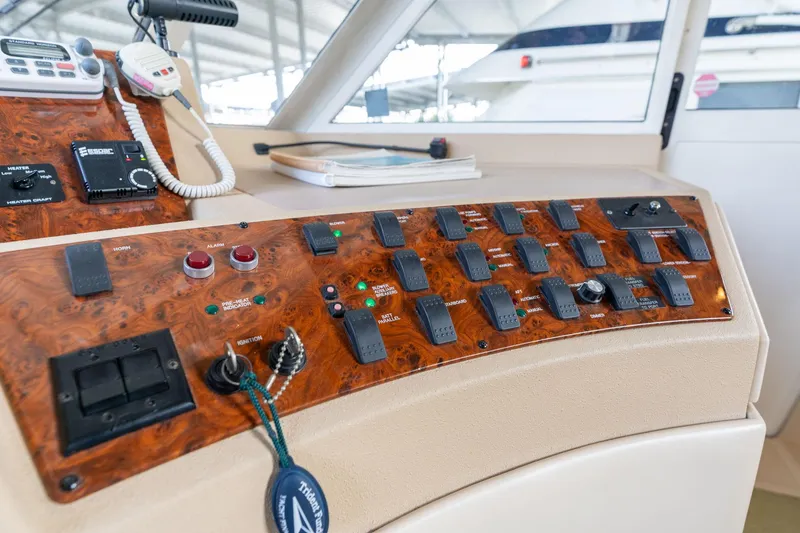 Slide: The Image of Control panel of a 2003 Meridian 490 Pilothouse yacht with various switches and instruments. - 44