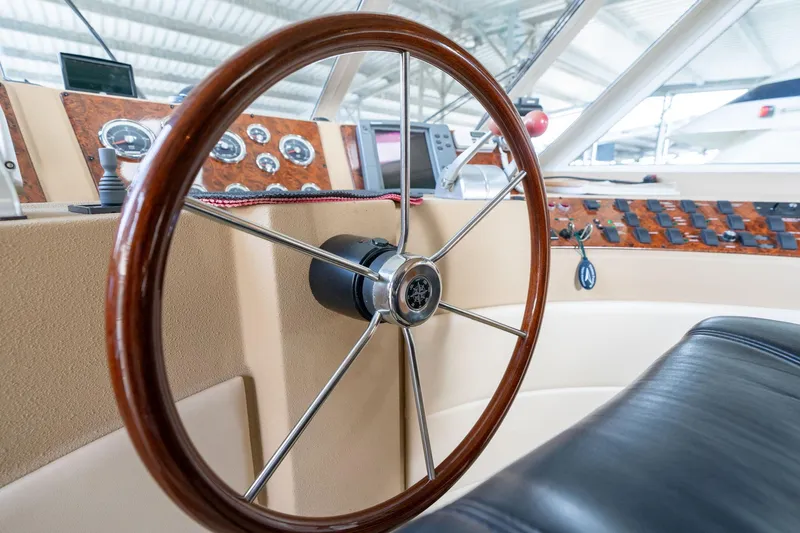 Slide: The Image of Steering wheel of 2003 Meridian 490 Pilothouse yacht, showcasing dashboard controls. - 48