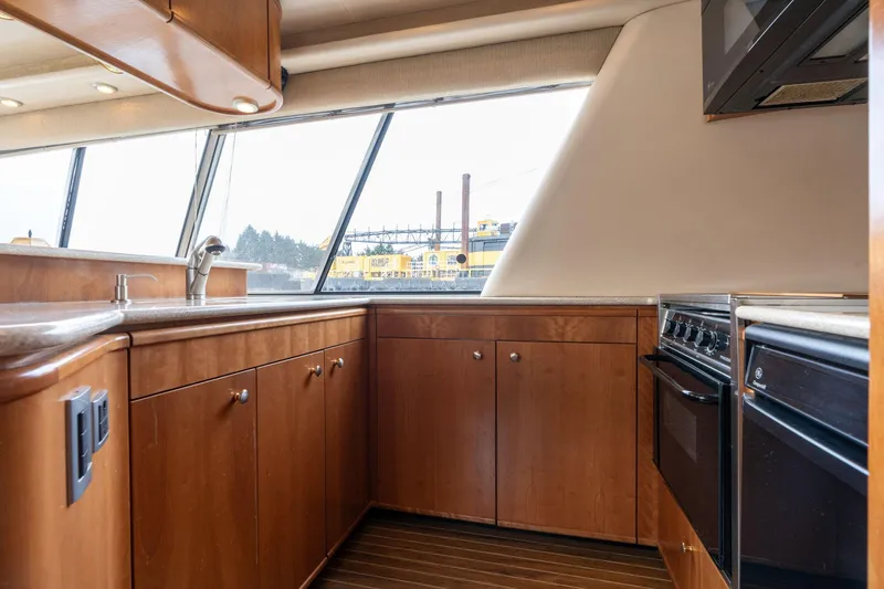 Slide: The Image of Interior of 2003 Meridian 490 Pilothouse yacht kitchen with wood cabinets and modern appliances. - 8