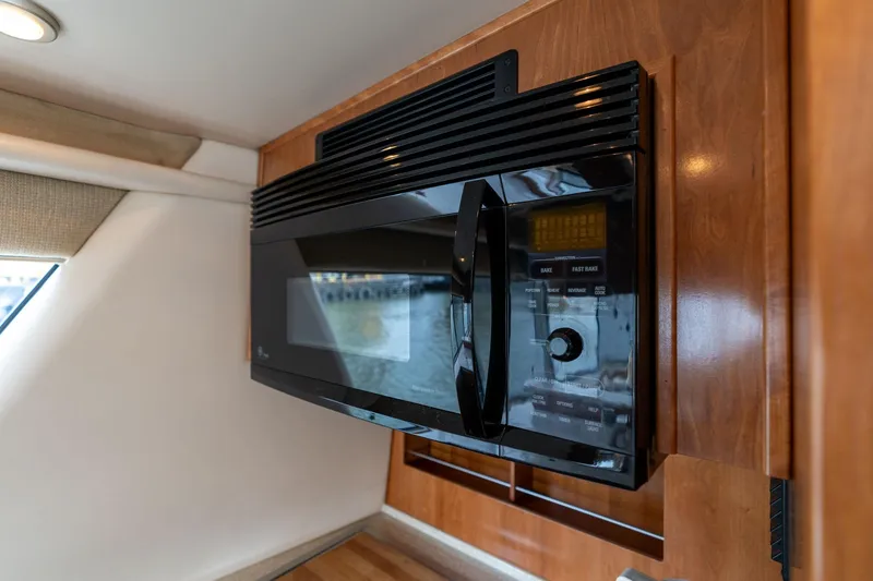 Slide: The Image of Microwave in 2003 Meridian 490 Pilothouse yacht kitchen, featuring wooden cabinetry. - 9