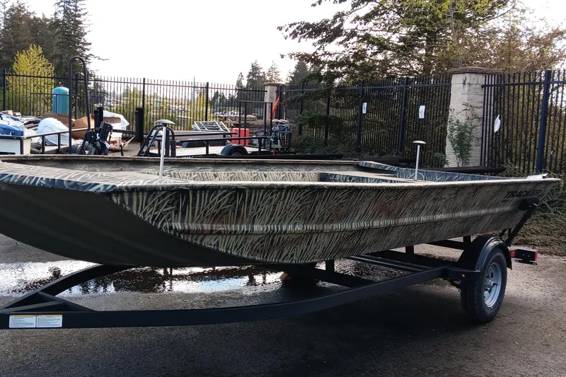 Slide: The Image of 2025 Tracker GRIZZLY 1860 Utility boat on trailer, parked outdoors. - 4