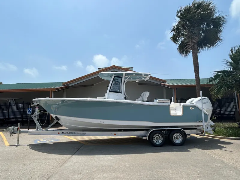 Slide: The Image of 2025 Sea Hunt Gamefish 27 with Coffin Box on trailer, parked near palm tree. - 0