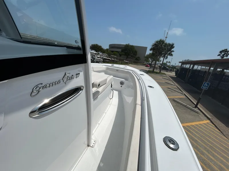 Slide: The Image of 2025 Sea Hunt Gamefish 27 boat with coffin box, docked under clear blue sky. - 13