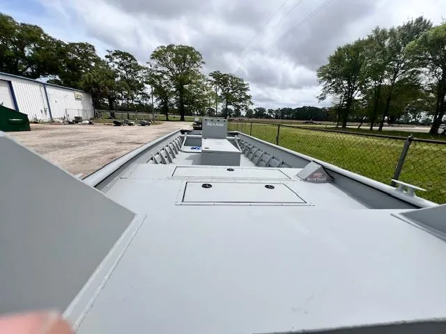 Slide: The Image of 2025 SeaArk 2472 Workhorse boat on display outdoors, surrounded by trees and fencing. - 3