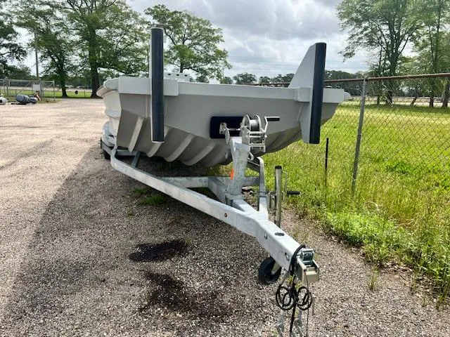 Slide: The Image of 2025 SeaArk 2472 Workhorse boat on trailer, parked outdoors near a fence. - 4