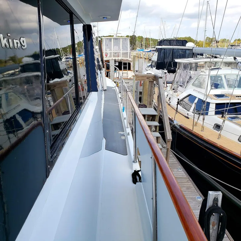 Slide: The Image of 1988 Viking 55 Motoryacht Walkaround docked at a marina, surrounded by other boats. - 12