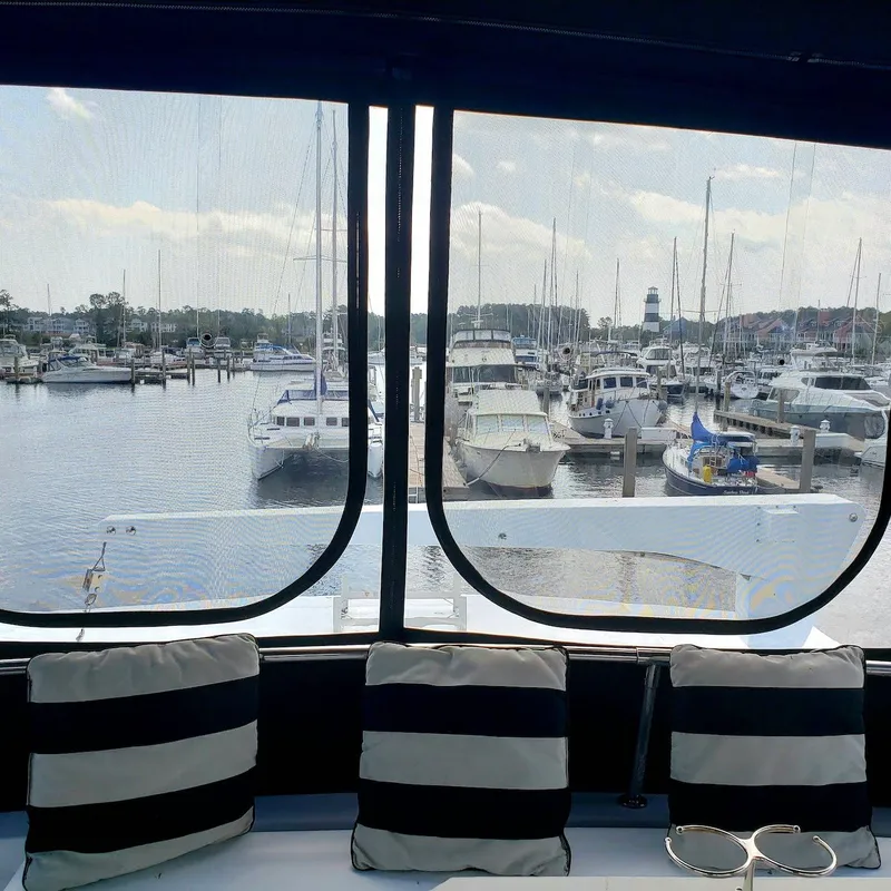 Slide: The Image of View from 1988 Viking 55 Motoryacht Walkaround, overlooking marina with boats and striped cushions. - 17