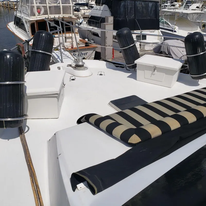 Slide: The Image of 1988 Viking 55 Motoryacht Walkaround with striped cushions and deck storage at marina. - 21