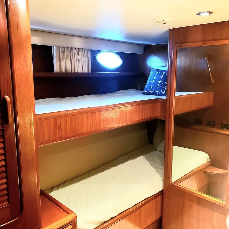 Slide: The Image of 1988 Viking 55 Motoryacht Walkaround cabin with wooden bunk beds and nautical decor. - 23