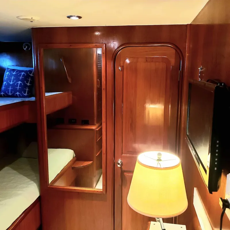 Slide: The Image of 1988 Viking 55 Motoryacht Walkaround cabin with wooden interior, bunk beds, and a lamp. - 29