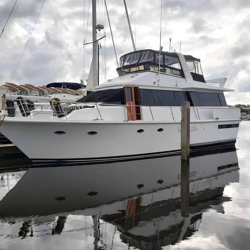 Slide: The Image of 1988 Viking 55 Motoryacht Walkaround docked, reflecting on calm water under cloudy skies. - 6