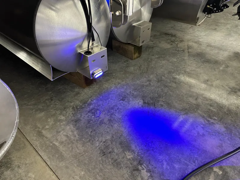 Slide: The Image of LED lights illuminating under Godfrey AquaPatio 255 SFLW pontoon, 2025 model, on concrete floor. - 14