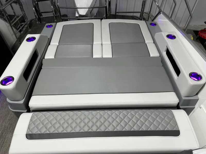 Slide: The Image of 2025 Godfrey AquaPatio 255 SFLW boat interior with gray and white cushioned seating. - 16