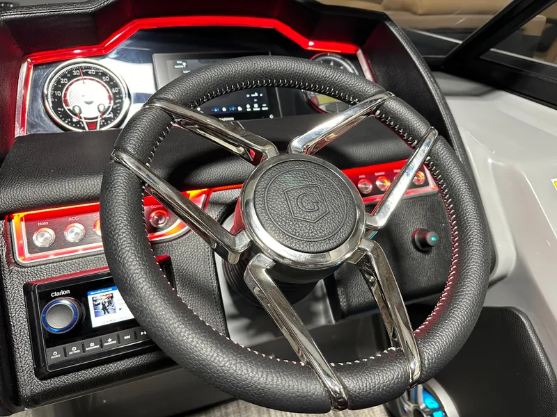 Slide: The Image of Steering wheel of 2025 Godfrey AquaPatio 255 SFLW with illuminated dashboard controls. - 21
