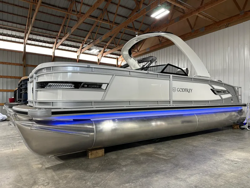 Slide: The Image of 2025 Godfrey AquaPatio 255 SFLW pontoon boat with sleek design and blue LED lighting. - 3