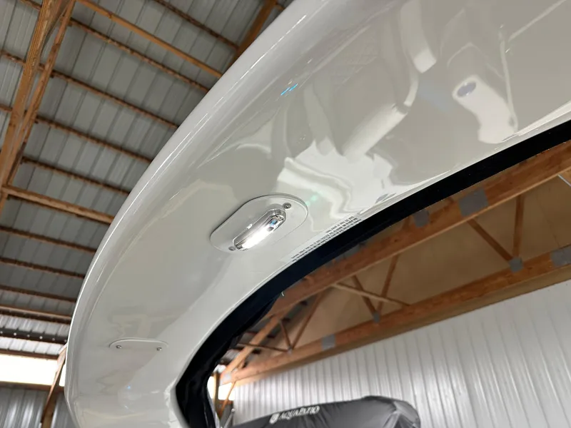 Slide: The Image of 2025 Godfrey AquaPatio 255 SFLW boat detail in a wooden-roofed storage area. - 31