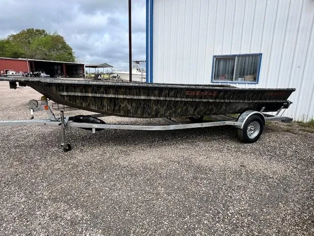 The Image of 2025 SeaArk DXS 1860 SLD boat on trailer, parked outside a building. - 0