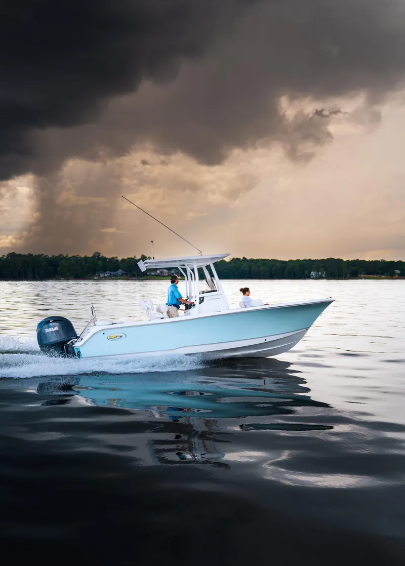 Slide: The Image of Sea Hunt Ultra 229 boat cruising on a lake under dramatic stormy skies, 2025 model. - 22