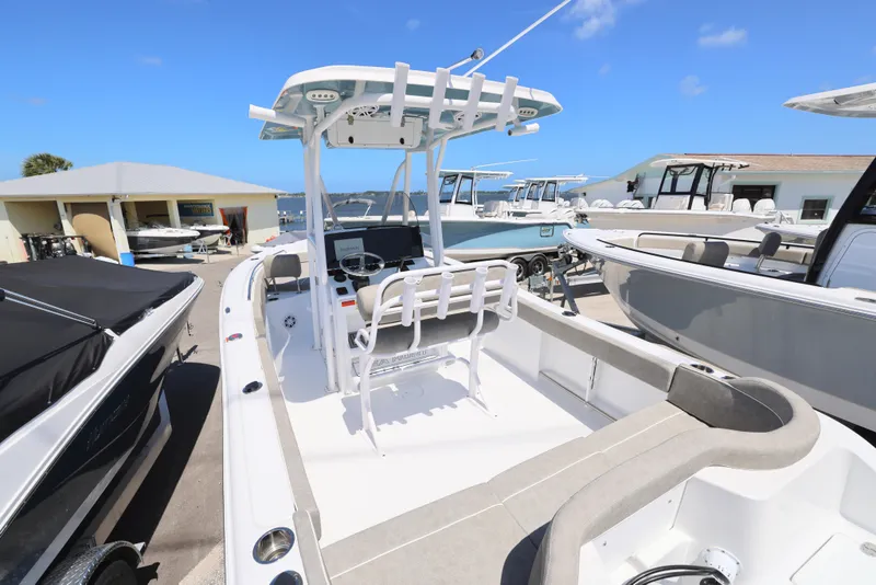 Slide: The Image of 2025 Sea Hunt Ultra 229 boat, spacious deck, modern design, docked under clear blue sky. - 5
