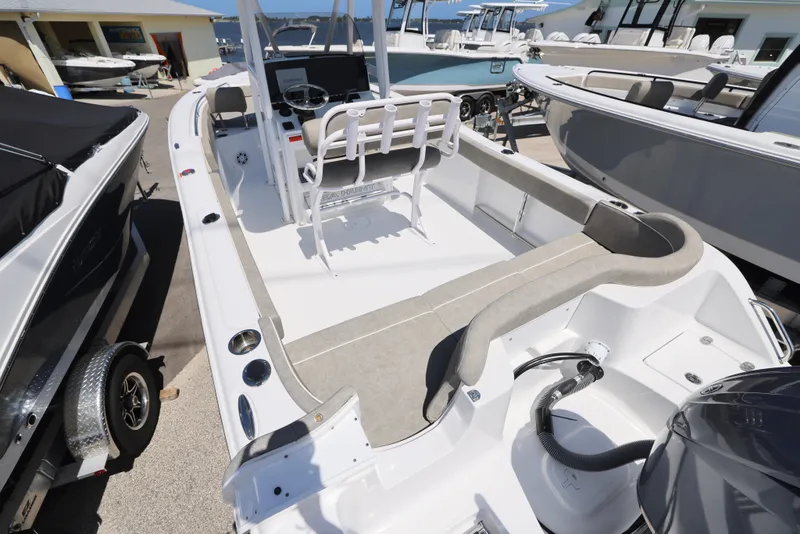 Slide: The Image of 2025 Sea Hunt Ultra 229 boat interior with seating and console, displayed in a marina. - 8