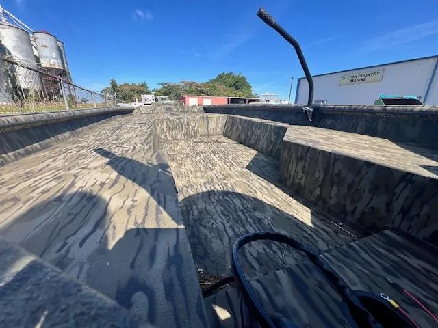 Slide: The Image of 2025 SeaArk 1752 Slayer Pro boat with camouflage interior, parked outdoors under clear blue sky. - 5