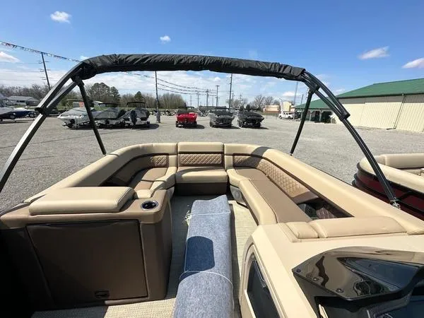 Slide: The Image of 2023 Godfrey Ap255sdc boat with spacious seating, parked outdoors under clear blue sky. - 16