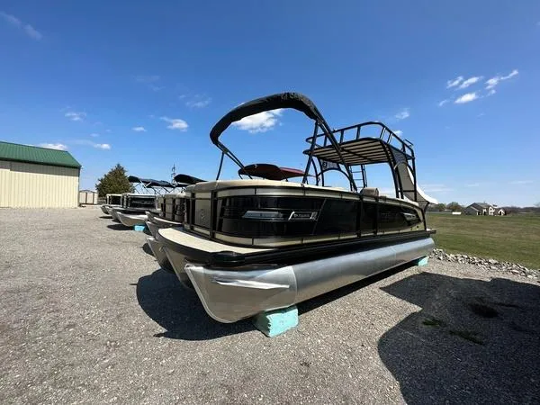 Slide: The Image of 2023 Godfrey Ap255sdc pontoon boat displayed outdoors on gravel under clear blue sky. - 3