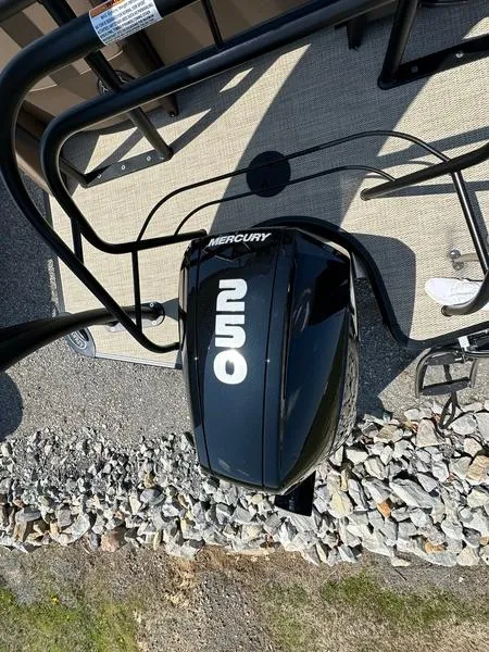 Slide: The Image of 2023 Godfrey Ap255sdc boat with Mercury engine, top view on rocky ground. - 4