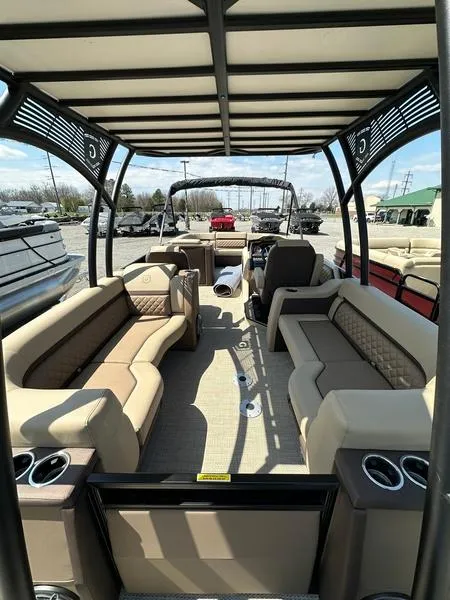Slide: The Image of 2023 Godfrey Ap255sdc pontoon boat with spacious seating and canopy, docked outdoors. - 6