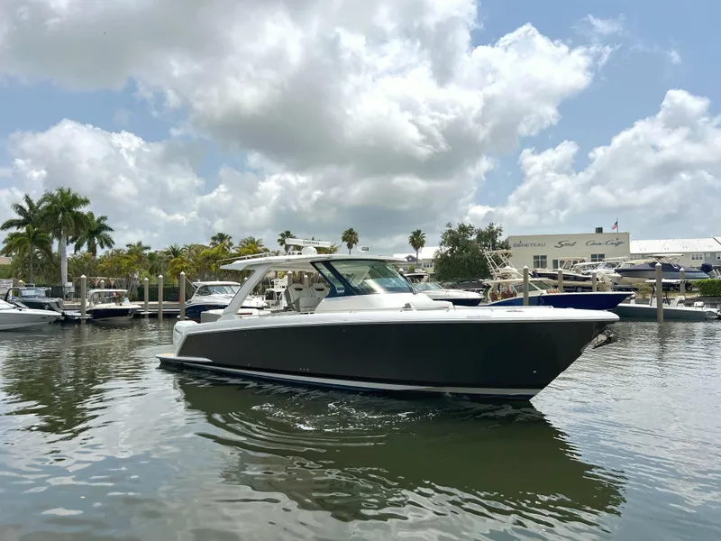 Slide: The Image of 2023 Tiara Yachts 38 LS cruising on a sunny day with palm trees in the background. - 3