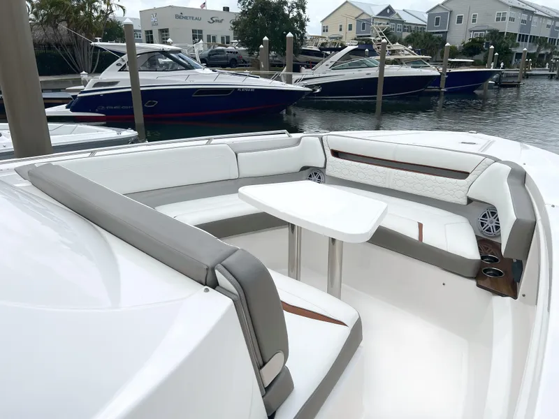 Slide: The Image of 2023 Tiara Yachts 38 LS with spacious seating and table in a marina setting. - 44
