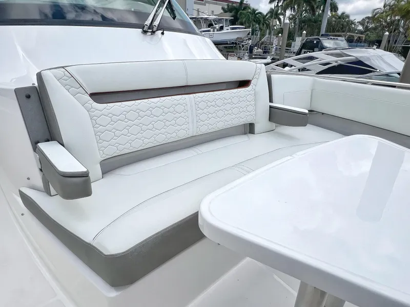 Slide: The Image of 2023 Tiara Yachts 38 LS interior with white seating and table, docked at marina. - 45