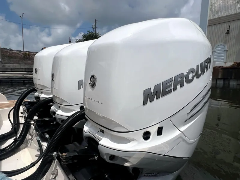 Slide: The Image of Triple Mercury outboard engines on a 2023 Tiara Yachts 38 LS, docked by the water. - 6
