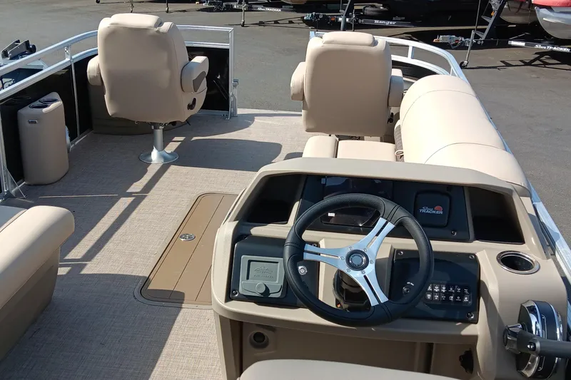 Slide: The Image of 2025 Sun Tracker Sportfish 24 XP3 boat interior with steering wheel and seating. - 2