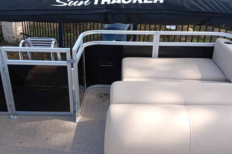 Slide: The Image of 2025 Sun Tracker Sportfish 24 XP3 pontoon boat interior with beige seating and railing. - 5
